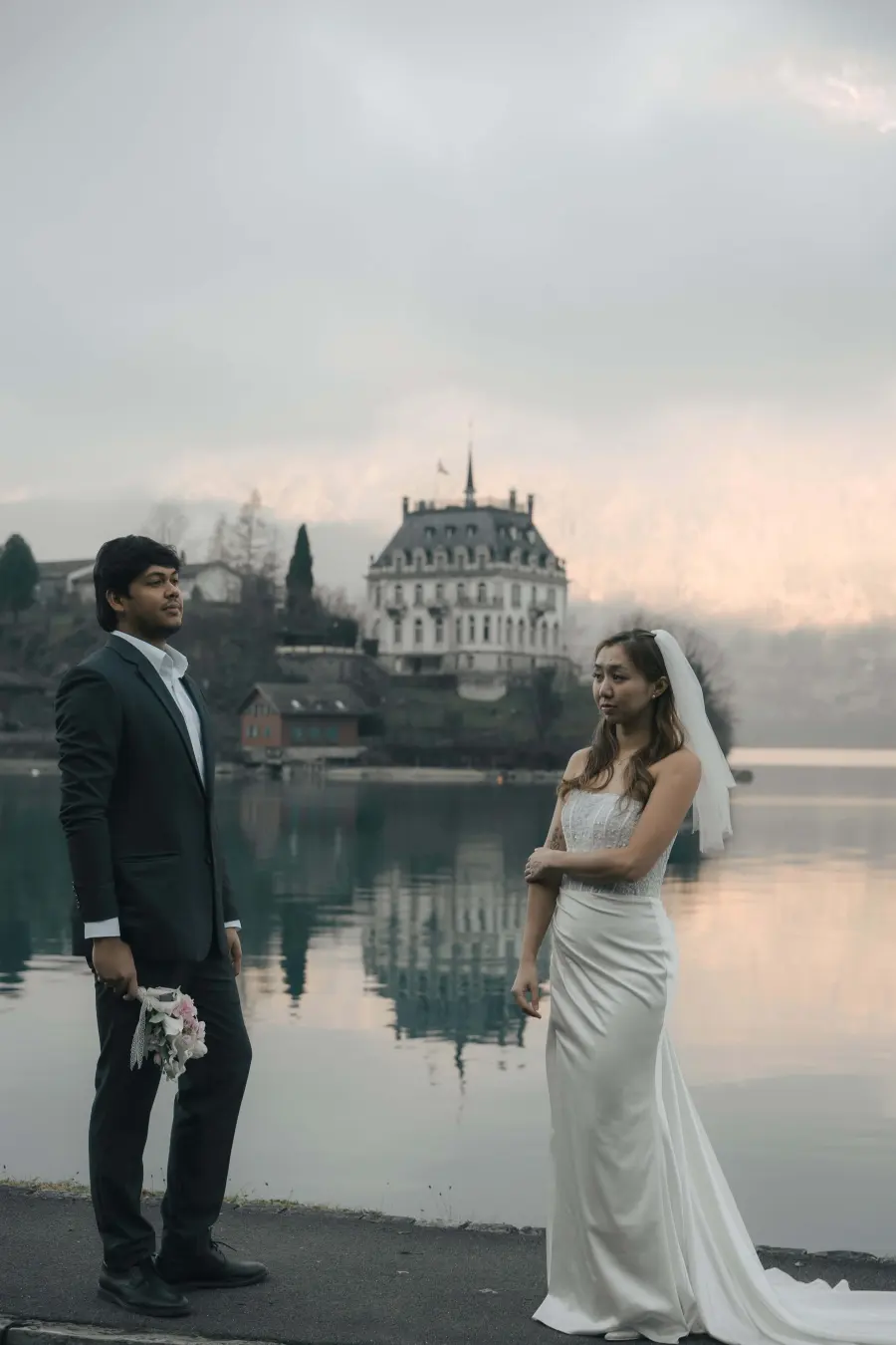 The cover of a finished Yours Fondly invitation: a couple standing by a lake at dusk, a manor house on the far shore.